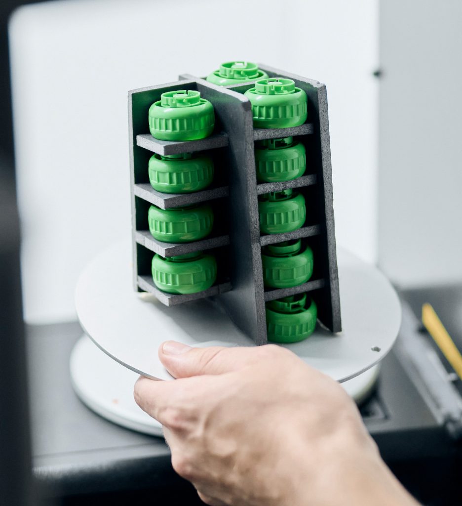 Mulziple green parts in a part fixture a placed in a CT scanner